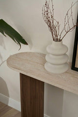 Moderne ovalt sidebord med top i travertinlook og melaminbund i valnød. Stilfuldt minimalistisk design.